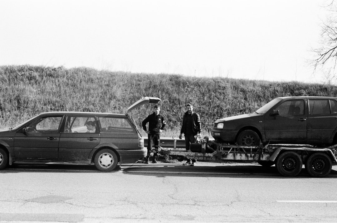 a-couple-of-men-standing-next-to-a-couple-of-cars-with-surfboards-dlxuyflbt-u